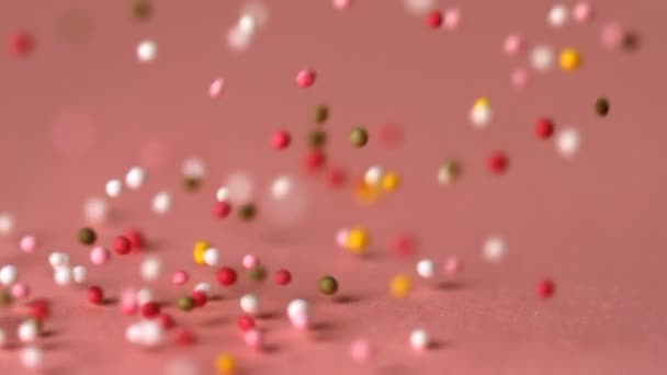 Streusel fallen auf rosa Oberfläche — Stockvideo