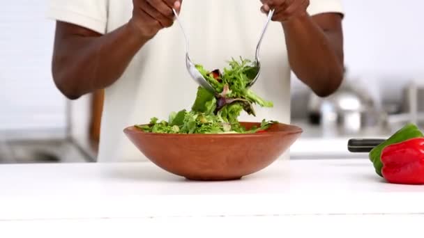 Hombre mezcla ensalada en la cocina — Vídeo de stock