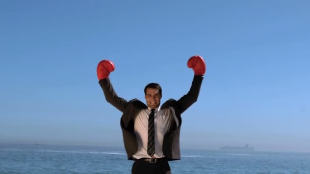 Businessman on the beach raising arms — Stok video