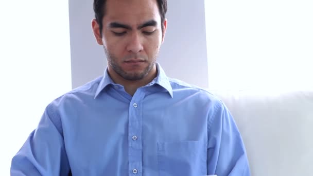 Portrait of a businessman using a laptop on a couch — Stock Video