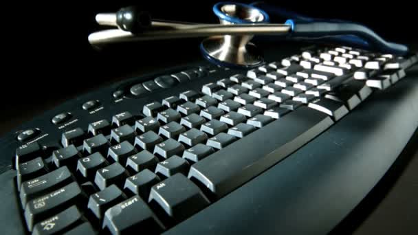 Синій стетоскоп відскакує після падіння на комп'ютерну клавіатуру — стокове відео