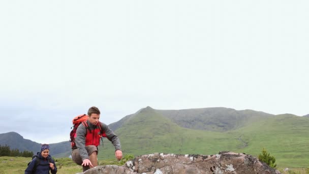 Wanderpaar erreicht den Gipfel und schaut sich um — Stockvideo