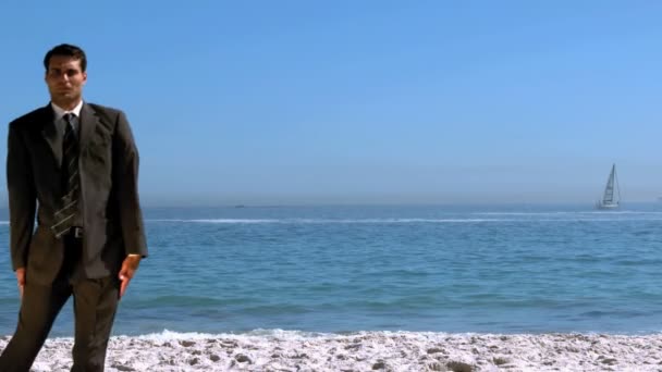 Hombre de negocios divertido saltando y cruzando la playa — Vídeos de Stock