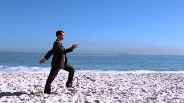 Businessman walking on the beach like a robot — Stock Video