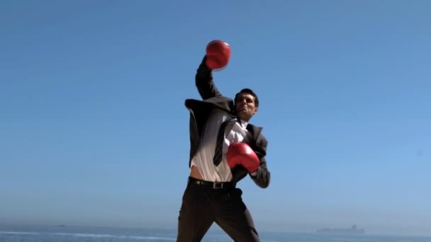 Atractivo hombre de negocios saltando con guantes de boxeo rojos — Vídeos de Stock