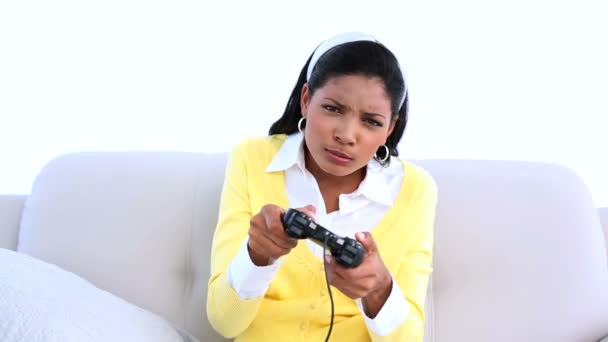Skoncentrowany kobieta, grając w gry wideo na kanapie — Wideo stockowe