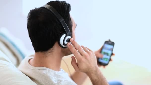Glad man lyssna på musik med sin smartphone — Stockvideo