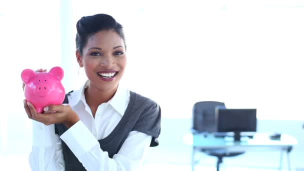 Mujer de negocios sonriente chequeando alcancía — Vídeos de Stock