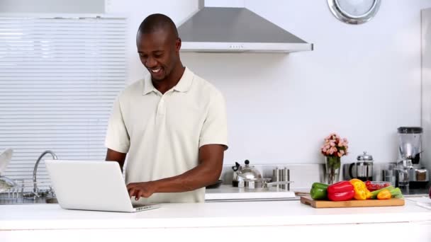 Homem com laptop em uma cozinha — Vídeo de Stock