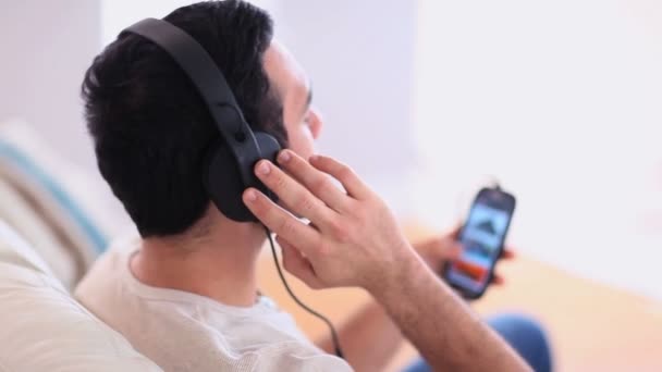 Красивый мужчина слушает музыку на телефоне — стоковое видео