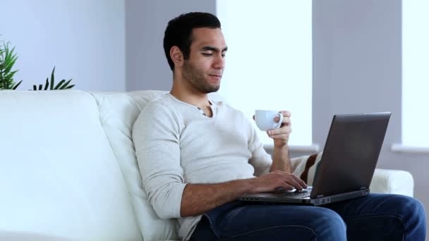 Άνθρωπος που πίνετε καφέ ενώ χρησιμοποιώντας ένα φορητό υπολογιστή — Αρχείο Βίντεο