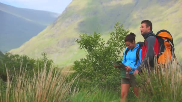 Aktivní pár turistiku s mapu a polohovací — Stock video