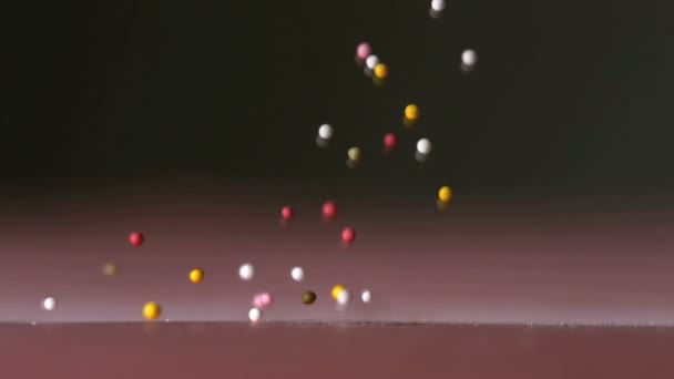 Many sprinkles falling on black surface — Stock Video