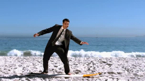 Homme d'affaires équilibrage sur une planche de surf sur la plage — Video