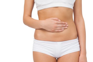 Mid section of slim woman touching her belly with one hand clipart