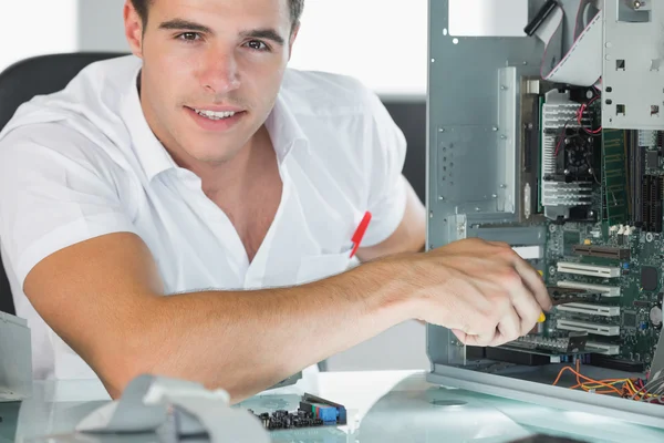 Ingeniero informático sonriente reparando la computadora con alicates —  Fotos de Stock