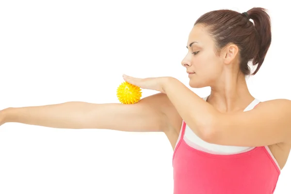 Mírové sportovní bruneta dotýká ramene s žlutým masážní koule — Stock fotografie