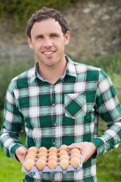 Jonge man houden karton van eieren — Stockfoto