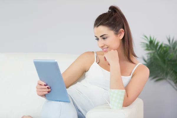 Vacker ung kvinna tittar på digital tablet — Stockfoto