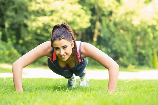 Smiling fit woman doing plank position — Stock Photo, Image