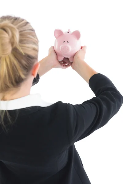 Mulher de negócios loira mostrando um banco porquinho — Fotografia de Stock