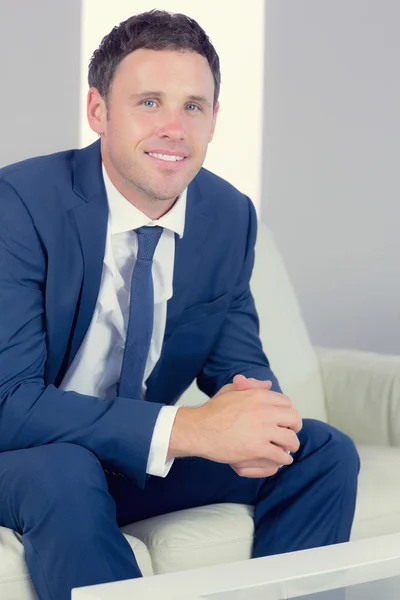 Cheerful handsome businessman relaxing on couch — Stock Photo, Image