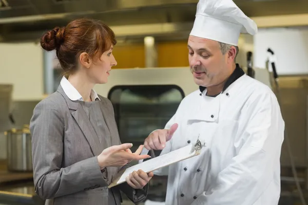 Jonge vrouwelijke manager praten met de chef-kok — Stockfoto