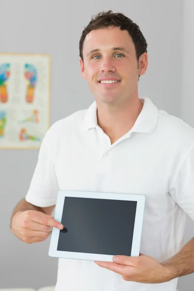 Guapo fisioterapeuta alegre mostrando tableta — Foto de Stock