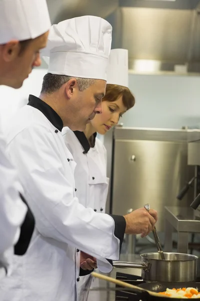 Chefkoch inspiziert den Topf seiner Schüler — Stockfoto