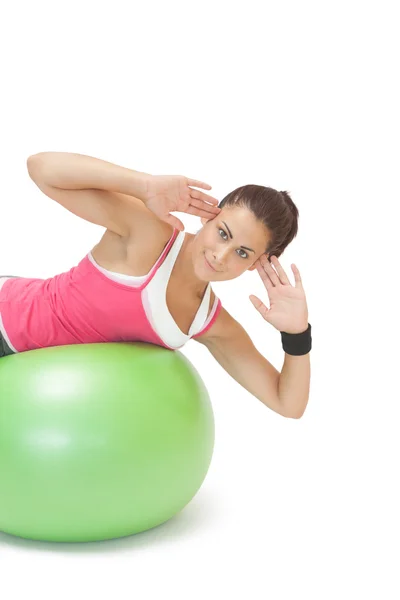 Sonriente morena deportiva haciendo ejercicio sobre pelota de ejercicio — Foto de Stock