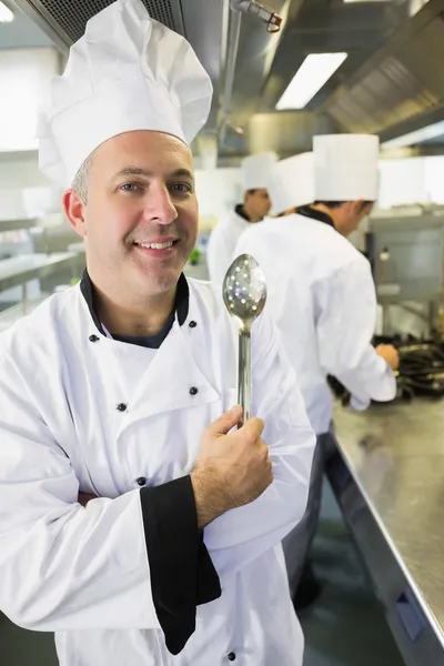 Chef sênior posando orgulhosamente em uma cozinha — Fotografia de Stock