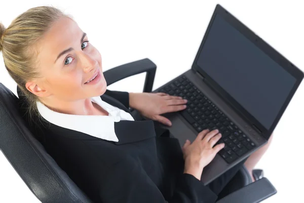 Linda mujer de negocios usando su cuaderno sentado en una silla de oficina — Foto de Stock