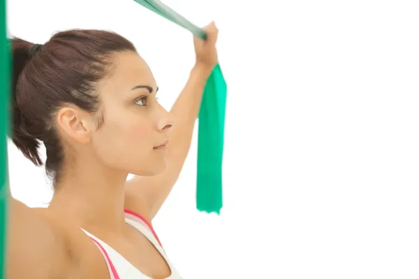 Serious sporty brunette stretching with resistance band — Stock Photo, Image