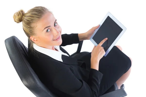 Fröhliche junge Geschäftsfrau sitzt mit ihrem Tablet auf einem Bürostuhl — Stockfoto