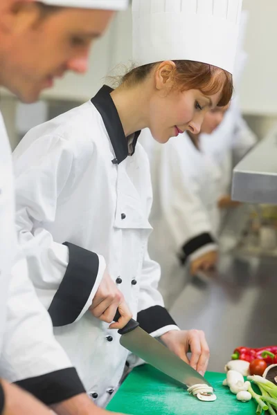 Bonito chef cortando cogumelos com colegas — Fotografia de Stock