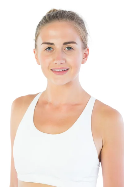 Attractive smiling blonde wearing sports bra looking at camera — Stock Photo, Image