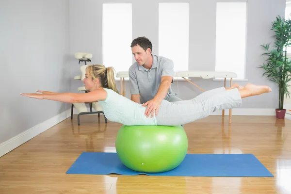 Physiotherapist helping patient doing exercise with exercise ball — Stock Photo, Image