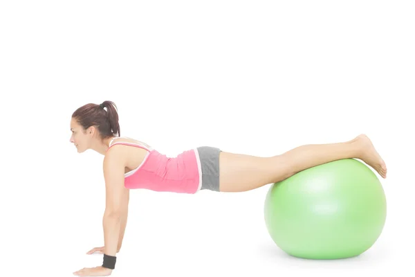 Content sporty brunette doing exercise with exercise ball — Stock Photo, Image