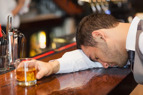 Пьяный бизнесмен лежит на прилавке — стоковое фото