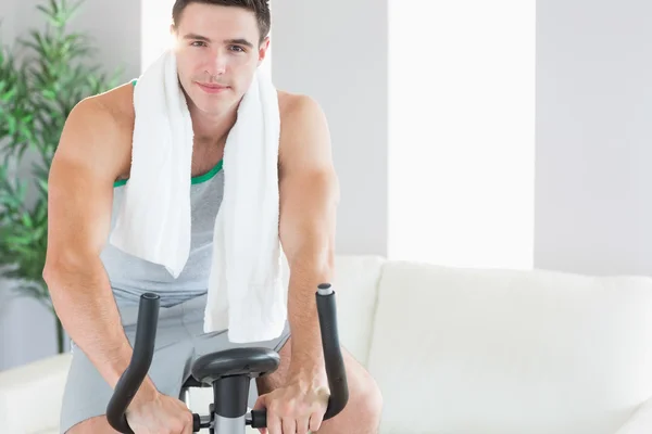 Content handsome man training on exercise bike — Stock Photo, Image