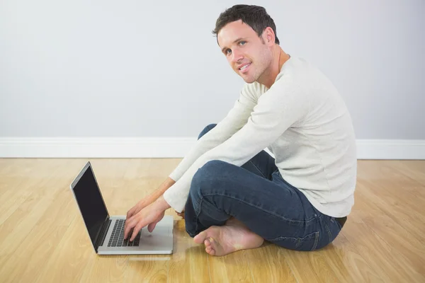 Casual inhoud man zit op de vloer met behulp van laptop — Stockfoto