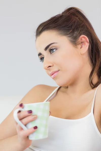 Schöne Frau Tagträumend auf einer Couch sitzend — Stockfoto