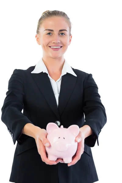 Empresária alegre atraente mostrando um banco porquinho — Fotografia de Stock