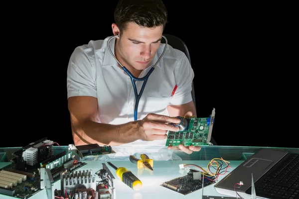 Ingénieur informatique attrayant examinant le matériel avec stéthoscope — Photo