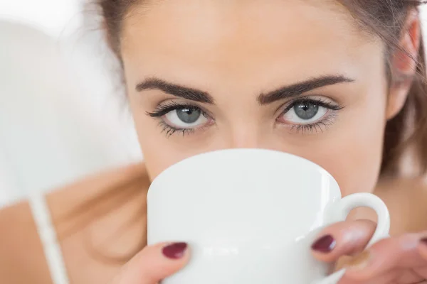 Närbild på en söt brunett kvinna dricker kaffe — Stockfoto