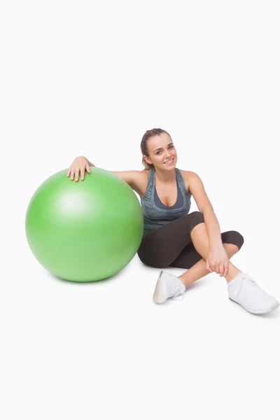 Спортивная женщина сидит рядом с мячом для фитнеса — стоковое фото