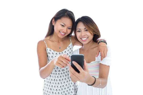 Lachende jonge vrouwen met behulp van een smartphone — Stockfoto