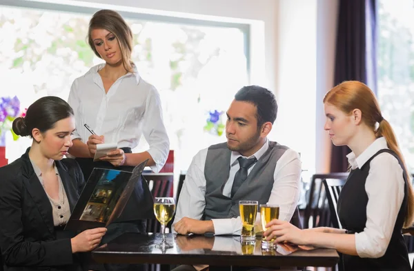 Drie mensen uit het bedrijfsleven een diner in restaurant bestellen — Stockfoto