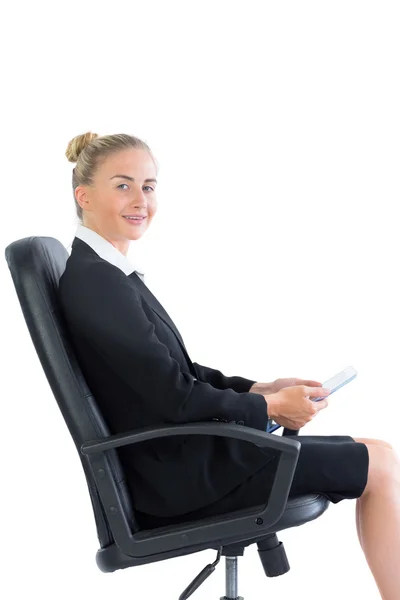 Hermosa joven empresaria sentada en una silla de oficina sosteniendo su tableta —  Fotos de Stock