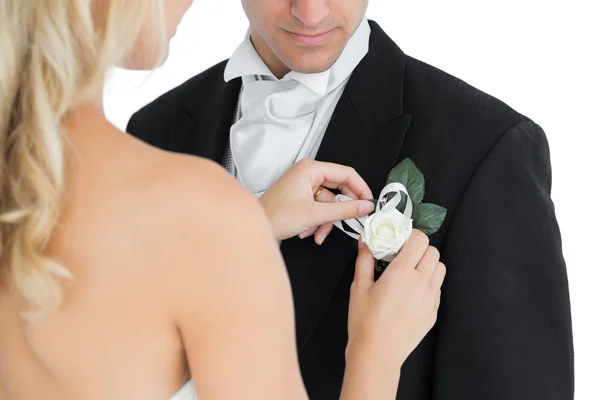 Blonde bride pinning a flower on the suit of her husband — Stock Photo, Image